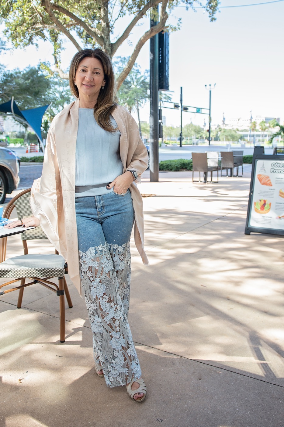 Carrie standing outdoors in a soft wrap, smiling