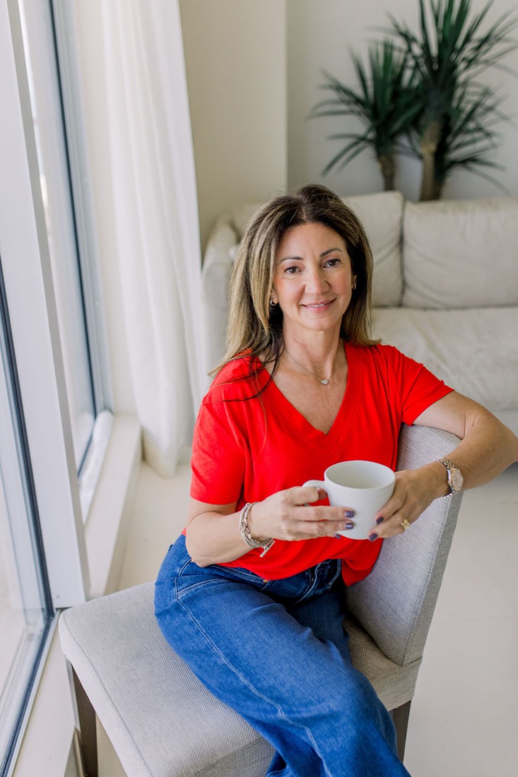 Carrie in a red top holding a coffee cup